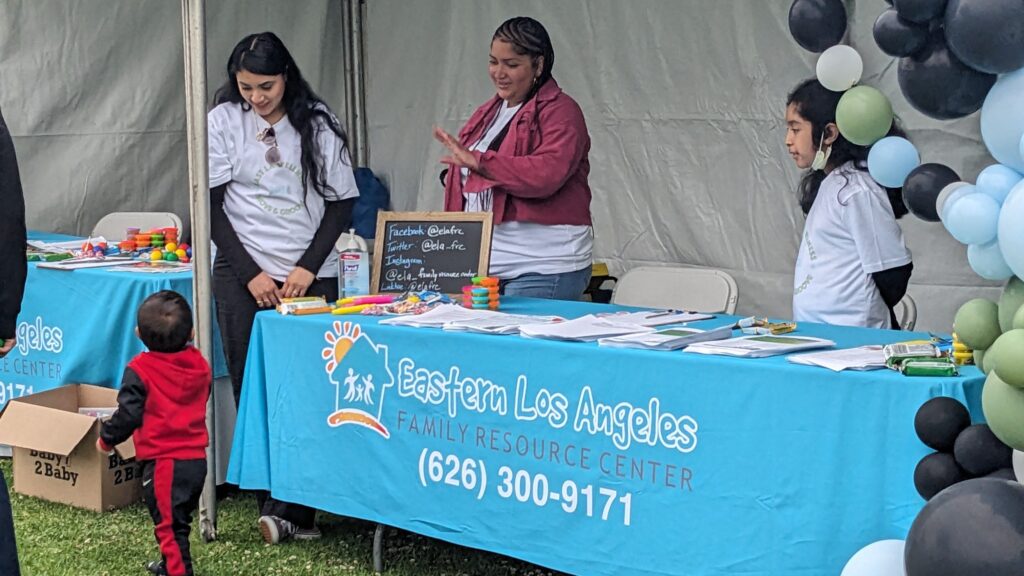 Team members from the Eastern Los Angeles Family Resource Center welcome a child to the "Move and Groove" wellness event on May 18, 2024. Photo by Heluna Health.